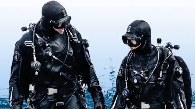 Two divers walking out of the water