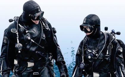 Two divers walking out of the water